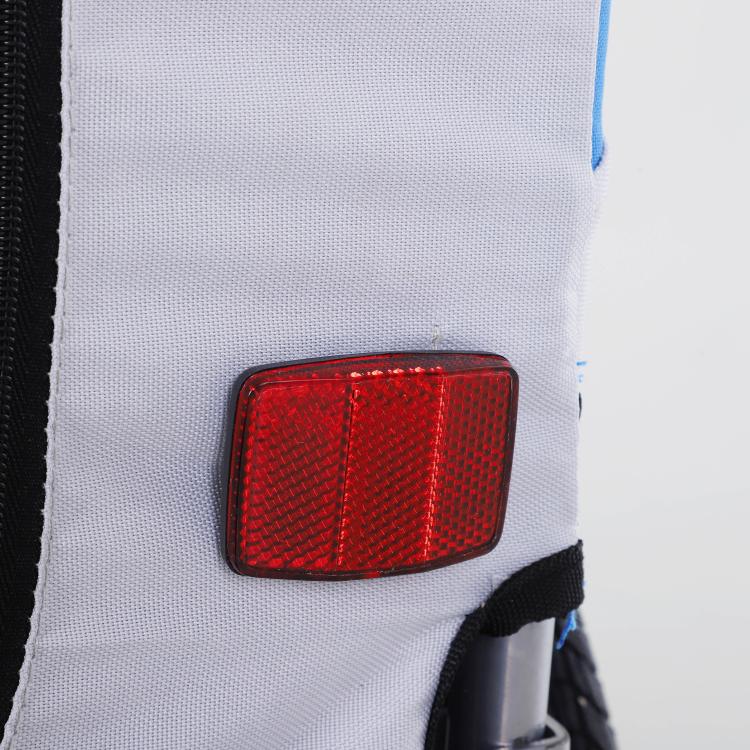 Red rear reflector on a blue and white pet bike trailer panel