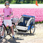 Blue child bike trailer with two wheels, clear canopy, and rear safety flag