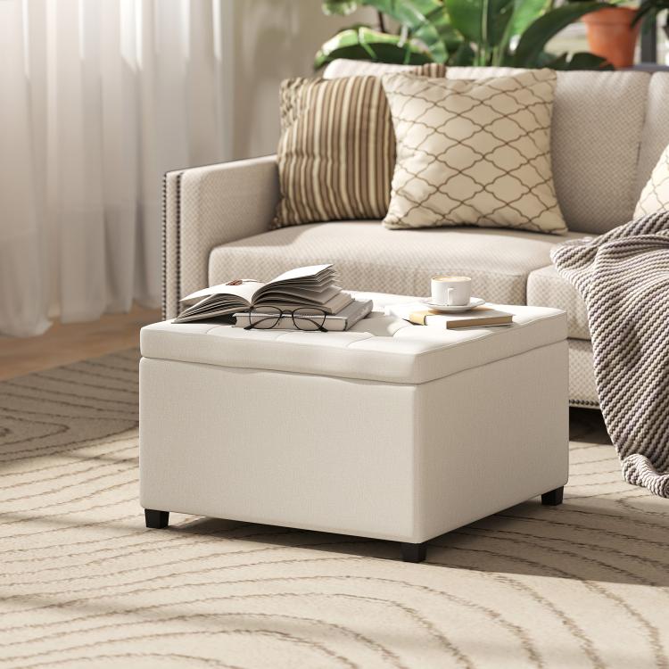 Beige square ottoman bench with flip-top lid, button-tufted seat, and dark feet