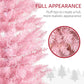 Pink artificial Christmas tree with dense tips close-up and warm white glow