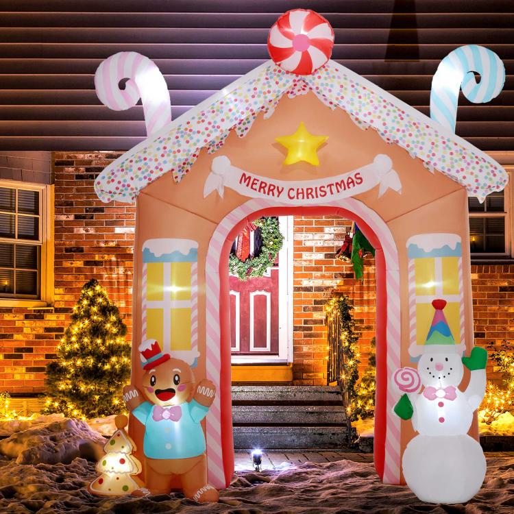Lit candy house inflatable archway with gingerbread and snowman decorations on both sides