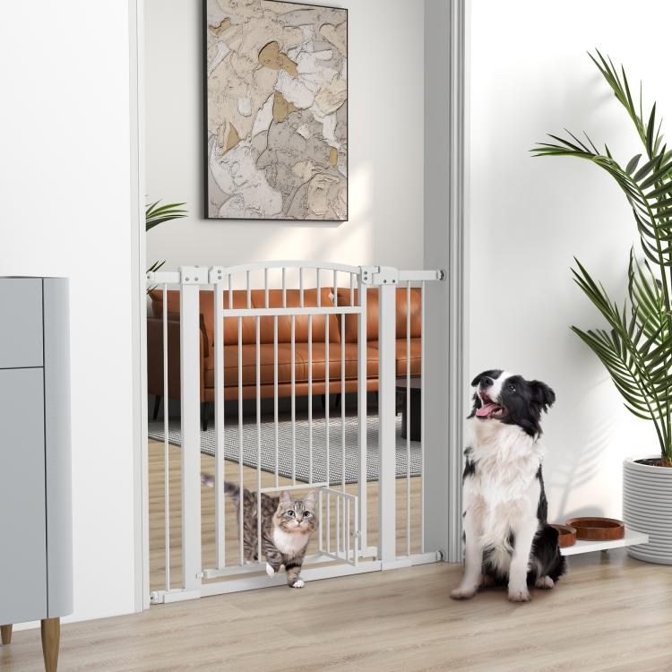 White walk-through pet gate installed in doorway with cat and dog nearby