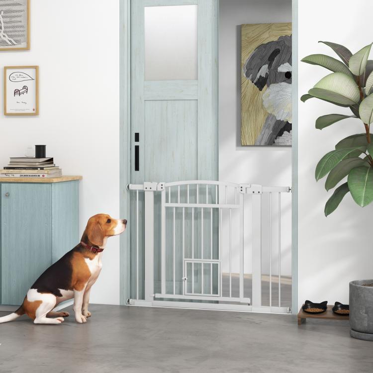 White walk-through pet gate at doorway with vertical bars and top latch