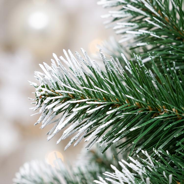 Close-up of pre-lit artificial Christmas tree branch tips with frosted look