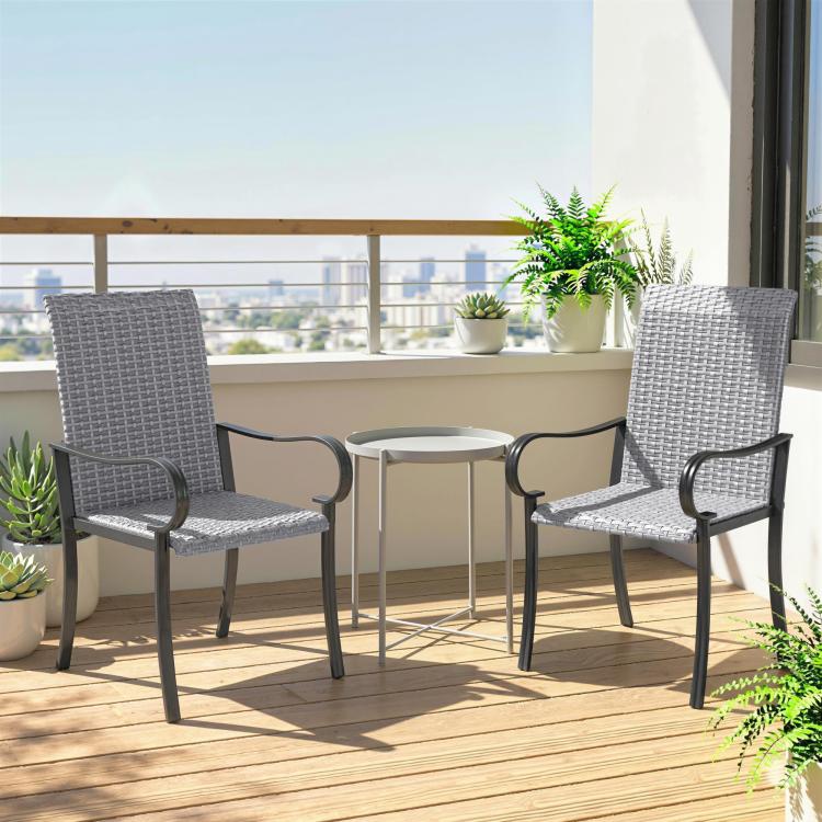 Two gray outdoor wicker dining chairs on a balcony patio with railing view