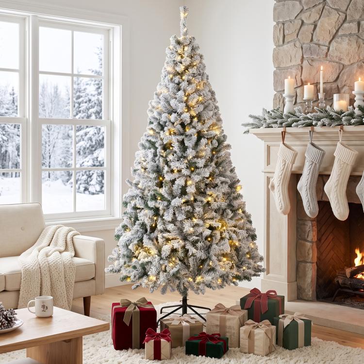 Snow-flocked prelit Christmas tree with warm white lights, dense tiered branches