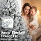 Snow-flocked Fraser Fir with white branch tips and warm lights.