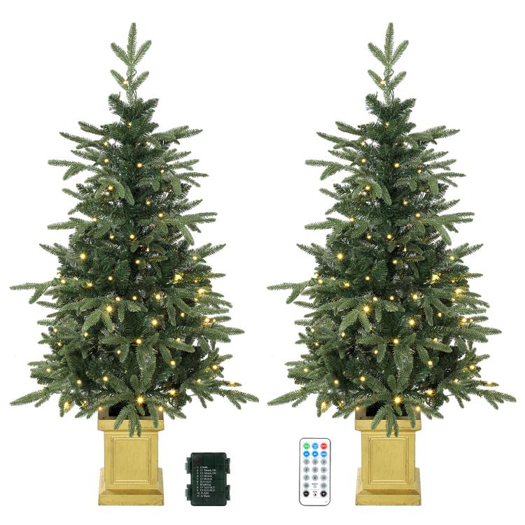Two small prelit Christmas trees with warm and cool lights and wooden-style display bases.