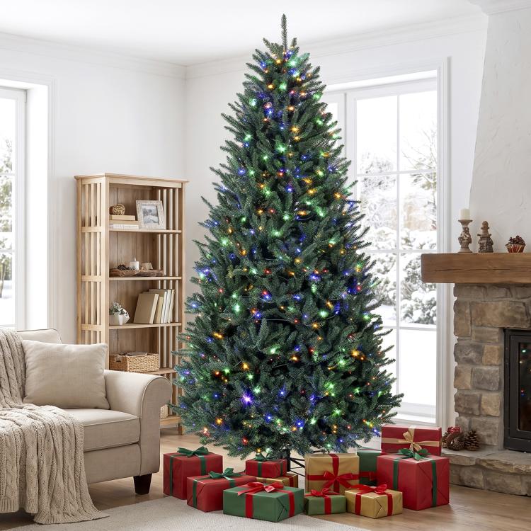 Tall artificial Christmas tree with green needles and multicolored lights