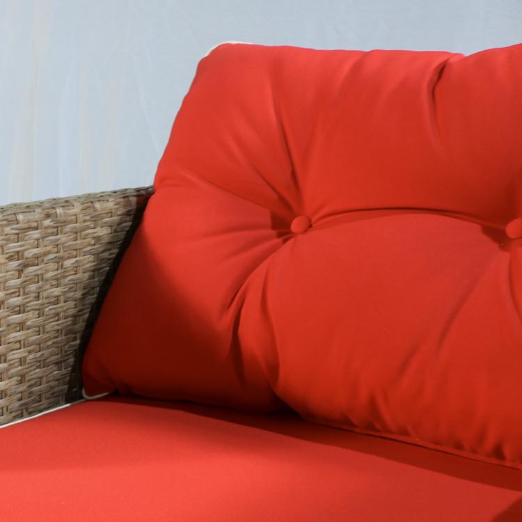 Close-up of red cushion with tufted back on a woven brown rattan seat