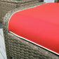 Close-up of red ottoman cushion edge with white piping on woven brown wicker