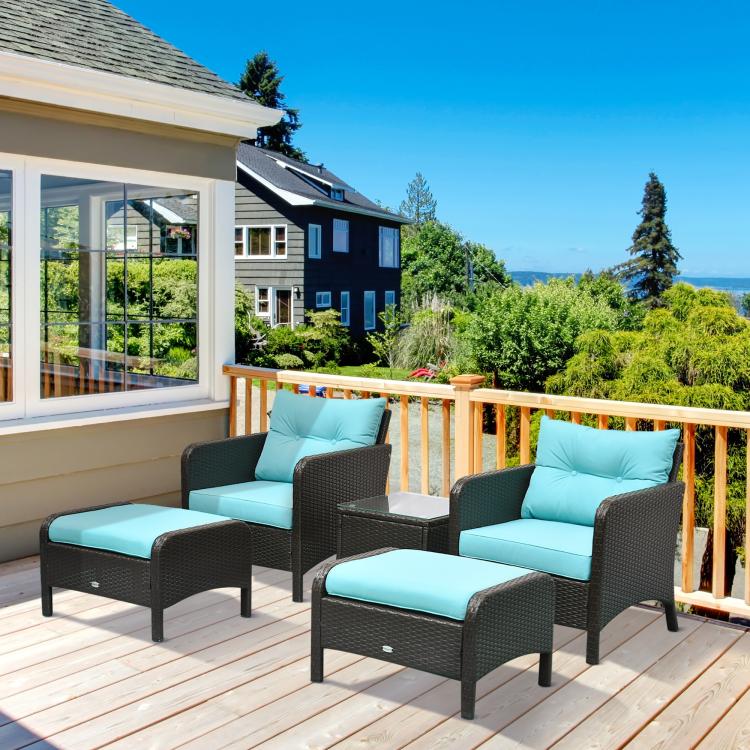 Outdoor dark wicker lounge chairs with teal cushions and matching ottoman seats on deck