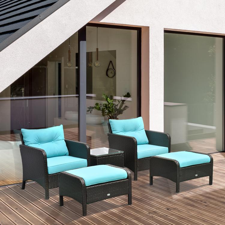 Pair of dark wicker lounge chairs with teal cushions and matching ottoman seats