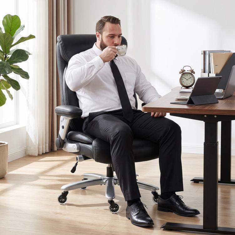 Black ergonomic office chair with headrest and casters, shown being used by a person