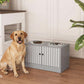 Tan dog sitting beside gray elevated feeding station with two stainless steel bowls