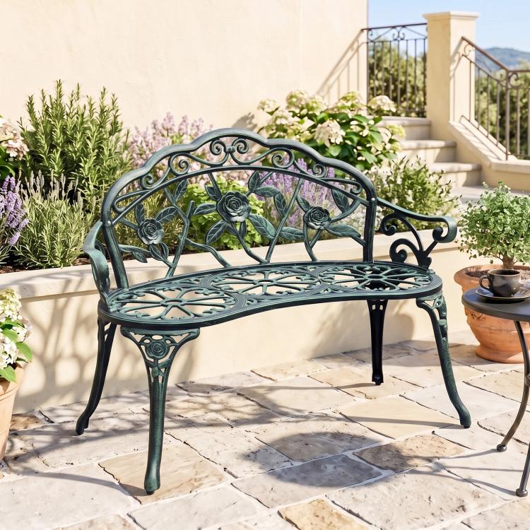 Green decorative metal bench with curved scroll back and rose rosette accents