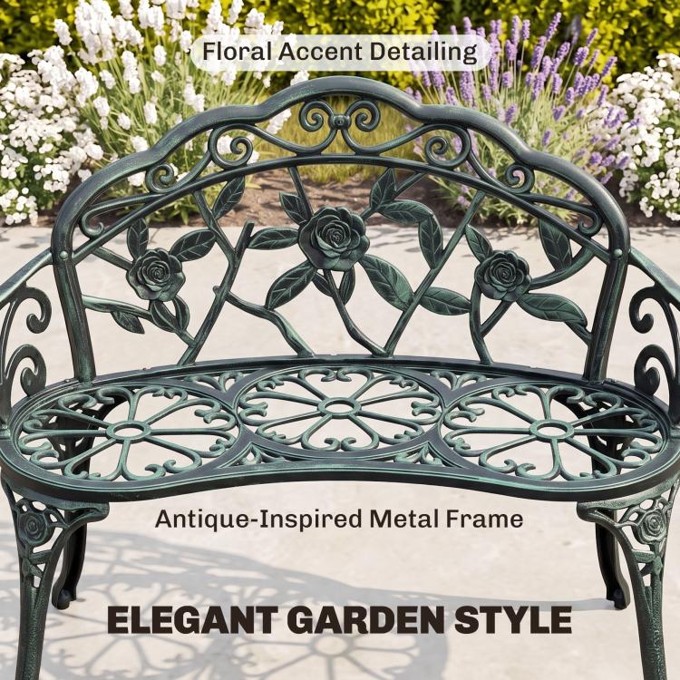 Green cast aluminum bench with floral accent detailing on arched back and patterned seat