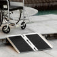 Aluminum folding wheelchair ramp with black anti-slip deck on concrete steps