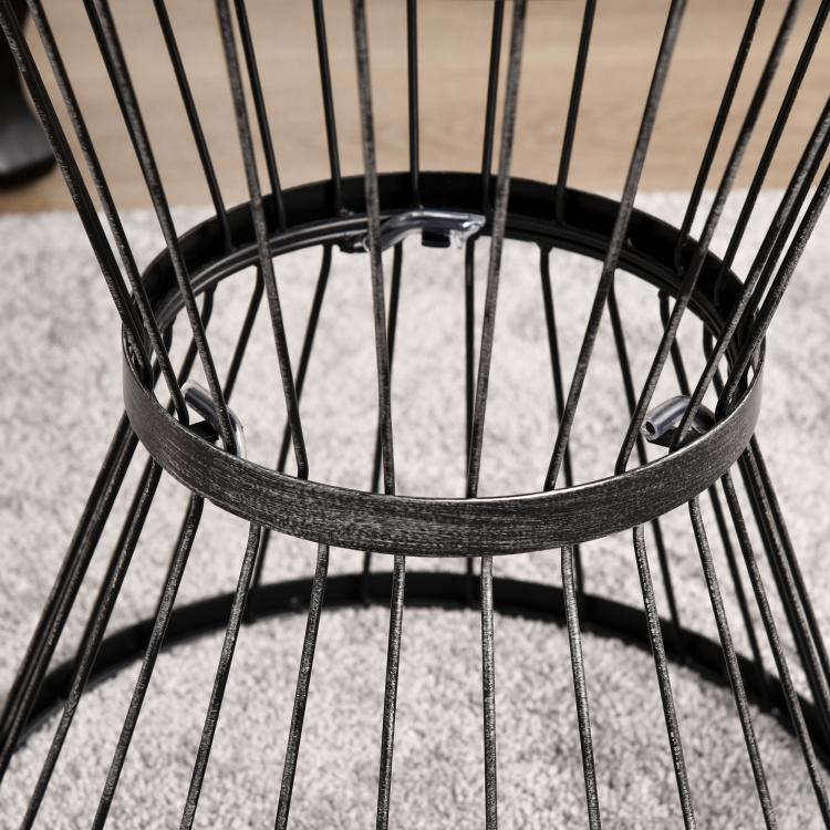 Close-up of black hourglass side table wire frame around the round tabletop
