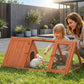 Wooden rabbit hutch on outdoor grass with open door and wire mesh enclosure