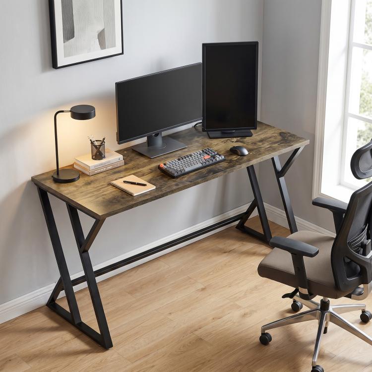 Rustic brown desk with black Z legs supporting dual monitors and keyboard