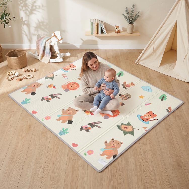 Reversible woodland animal play mat laid flat on floor, featuring colorful animal cartoon print