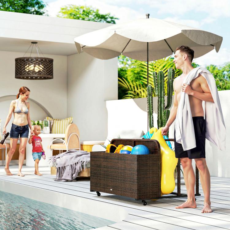 Rattan storage organizer with wheels holding pool floats on a patio near a pool