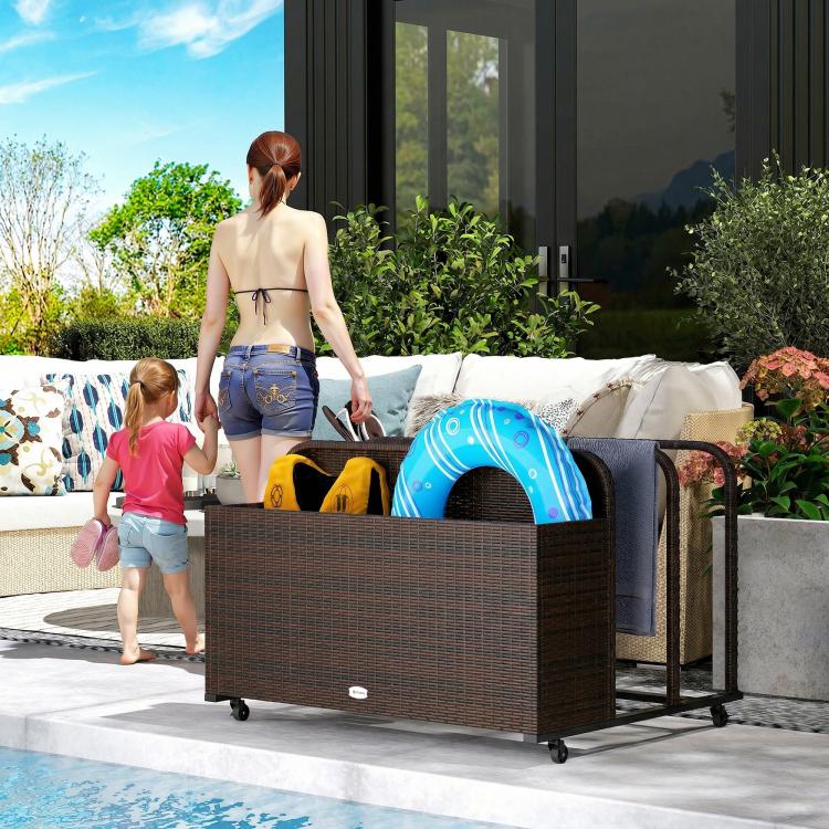 Mixed brown rattan organizer with wheels holding pool floats on an outdoor deck