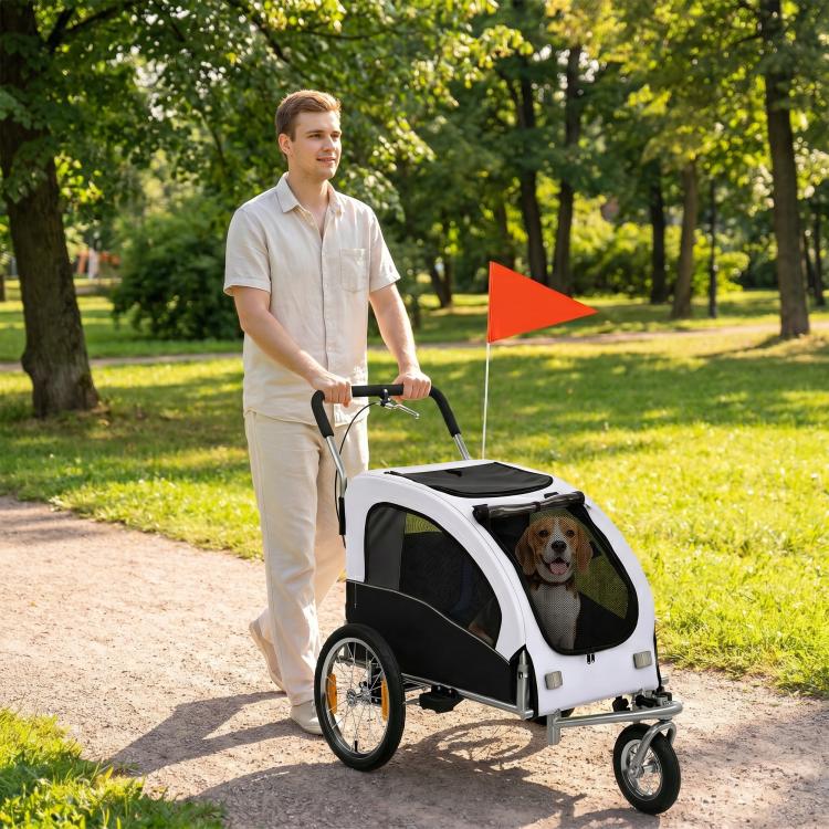 White pet bike trailer stroller with dog inside, black roof pad, pushed along a path