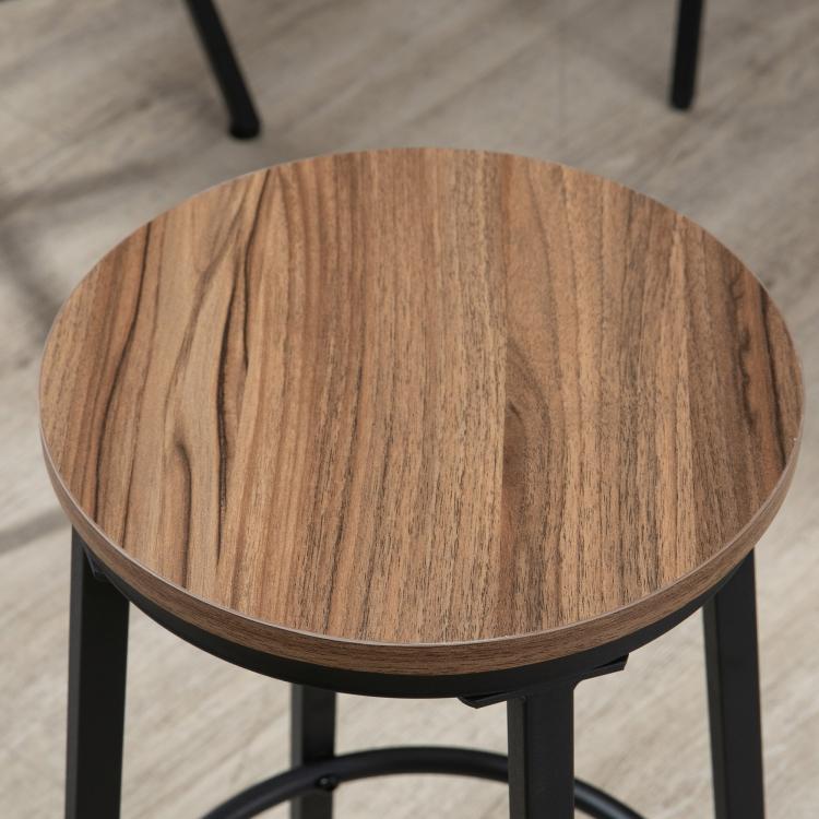Round wood-look tabletop close-up with dark edge and black metal base legs.
