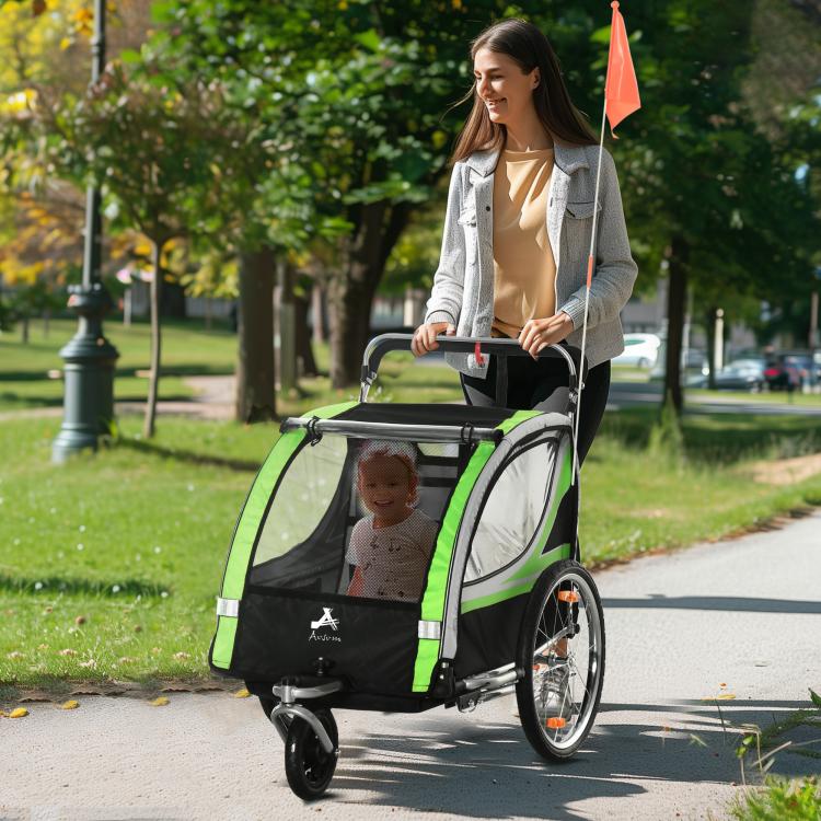 Green and black double child bike trailer with child visible through front window