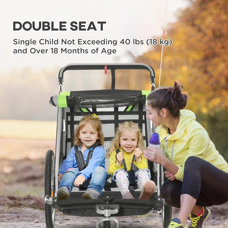 Green double child bike trailer with two kids seated under front canopy frame