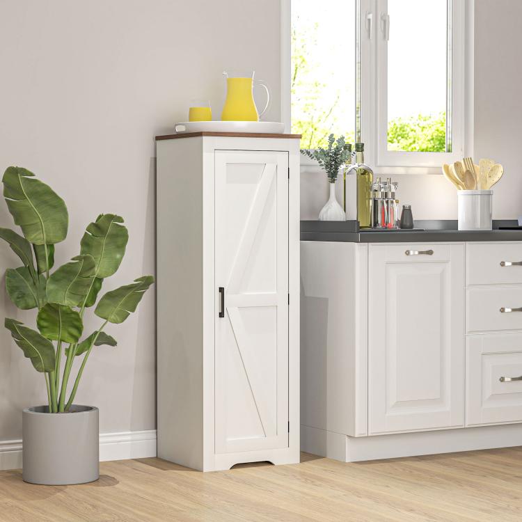 White farmhouse storage cabinet with barn-style door and black handle, kitchen corner view.