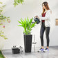 Black tall woven planter with drainage tray, shown next to a person