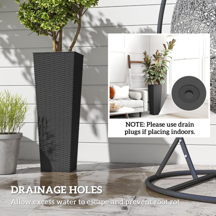 Tall black plastic planter with rattan-style texture beside indoor plant display