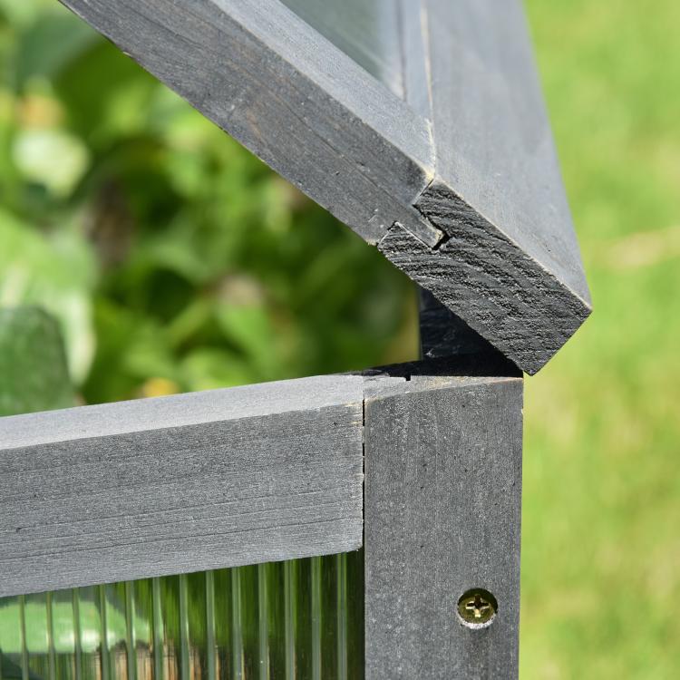 Mini cold frame greenhouse with gray wooden frame and polycarbonate panel joint