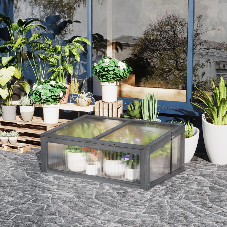 Gray mini cold frame greenhouse with clear polycarbonate panels on stone patio