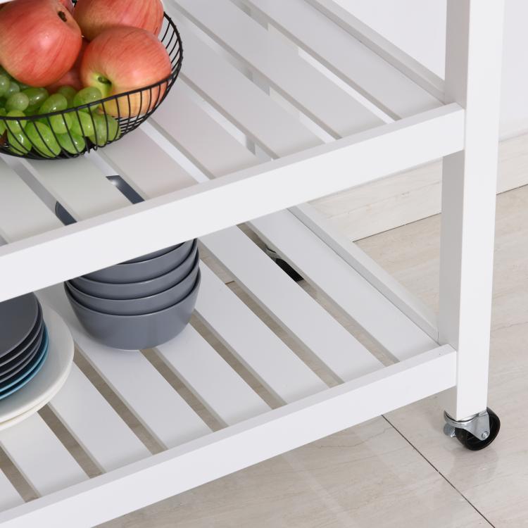 Close-up of slatted shelves on a white kitchen island cart with caster wheels