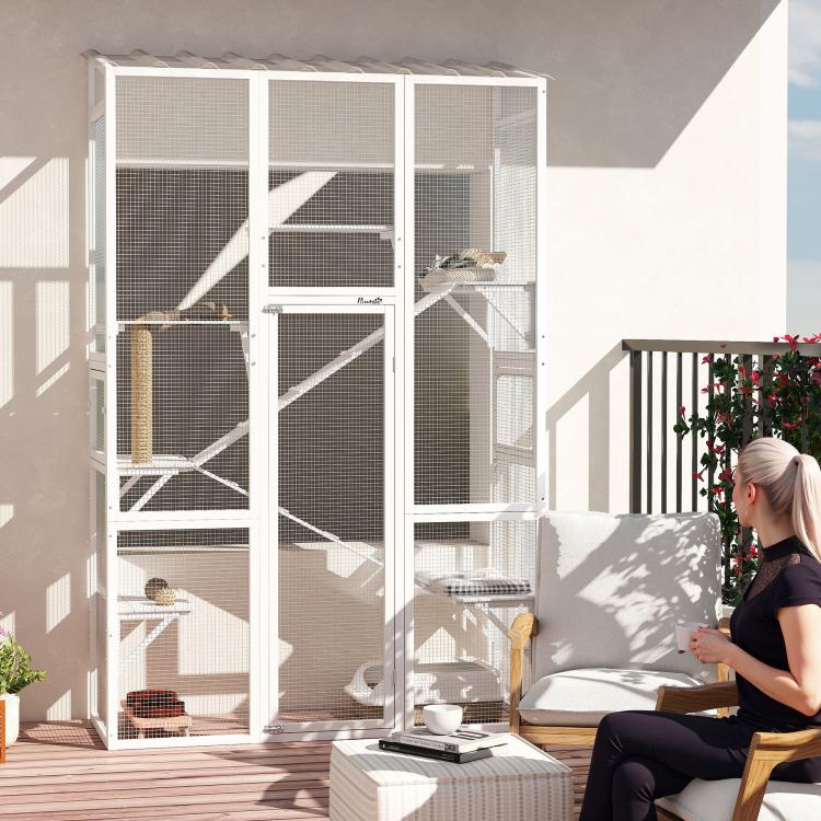 Large outdoor cat enclosure with mesh walls, platforms, ramps, and a scratching post