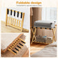 Foldable bamboo luggage rack with black straps and lower shelf, holding a suitcase