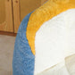 Oversized bean bag chair close-up with blue faux fur side and yellow-and-white seat