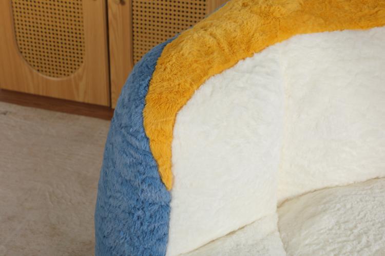 Close-up of blue faux fur bean bag chair with yellow trim and white inner cushion