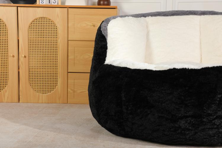 Oversized bean bag chair with black fuzzy outer and white padded backrest