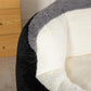 Bean bag chair corner with black faux fur exterior and white padded seat