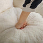 Person pressing into white faux fur cushion inside the bean bag chair