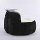 Oversized bean bag chair in black faux fur with gray rolled edge and white cushion