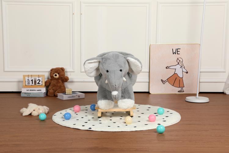 Grey plush elephant rocking toy on round mat with toy balls and wooden rocker base