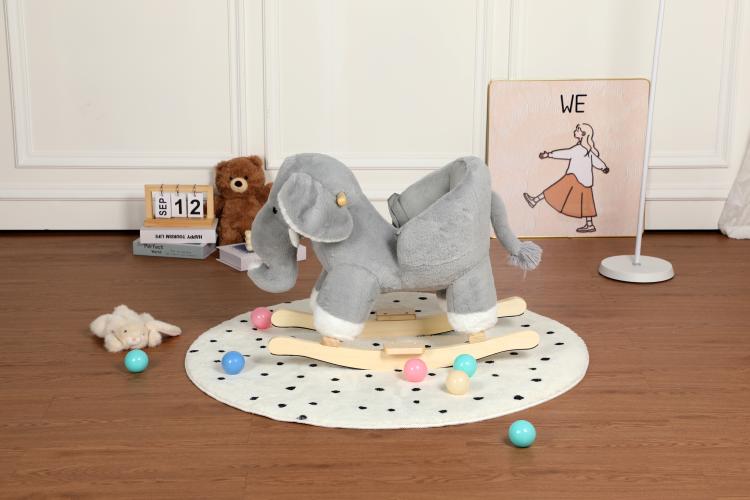Grey plush elephant rocking horse in 3/4 view on round mat with colorful balls