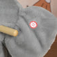 Grey plush elephant toy with wooden safety handle on the rocker seat