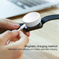 White magnetic charging puck being placed onto a smartwatch for charging.
